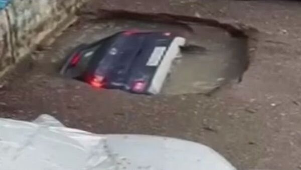 حفرة تبتلع سيارة في الهند بسبب الأمطار  - سبوتنيك عربي