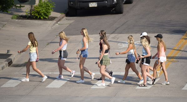مع ارتفاع درجات الحرارة إلى أكثر من ثلاث درجات، يسير صف من الفتيات على طول شارع ماركت في وقت متأخر من يوم حار في دنفر، الولايات المتحدة 15 يونيو 2021 - سبوتنيك عربي