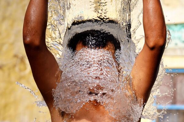 رجل يستحم في الهواء الطلق خلال يوم صيفي حار في أجمير، بولاية راجستان الهندية، 15 يونيو 2021 - سبوتنيك عربي