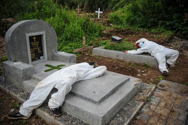 عمال يرتدون بدلات واقية، يستريحون بعد دفن ضحايا مرض كوفيد-19 في باندونغ، مقاطعة جاوة الغربية، إندونيسيا، في هذه الصورة التي التقطتها أنتارا فوتو  15 يونيو 2021  - سبوتنيك عربي