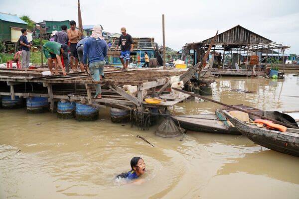 السكان يهدمون منازلهم العائمة على نهر تونلي ساب، وذلك بعد أن أُمروا بالمغادرة في غضون أسبوع واحد من إخطارهم من قبل السلطات المحلية في منطقة بريك بنوف، بنوم بنه، كمبوديا، 12 يونيو 2021 - سبوتنيك عربي