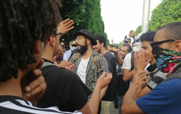 أحد المشاركين في مسيرة في شارع الحبيب بورقيبة بتونس للتنديد بقمع الشرطة للاحتجاجات الأخيرة، 18 يونيو/ حزيران 2021 - سبوتنيك عربي