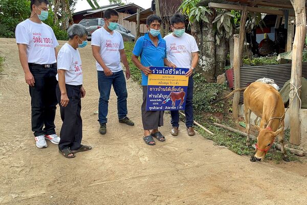 رجل يحمل لافتة بعد فوزه في حملة يانصيب للمقيمين الملقحين للفوز ببقرة حية أسبوعيًا، في إطار تعزيز حملة التطعيم المحلية ضد كوفيد-19 في مقاطعة شيانغ ماي، تايلاند، 8 يونيو 2021 - سبوتنيك عربي