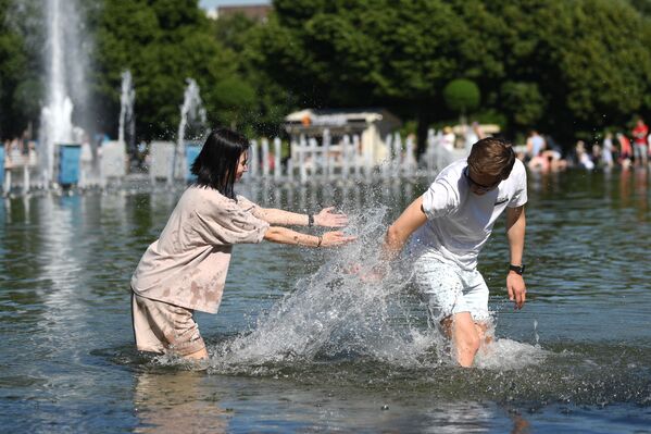 مواطنون يدخلون نافورة مياه في حديقة غوركي في موسكو، روسيا 19 يونيو 2021 - سبوتنيك عربي