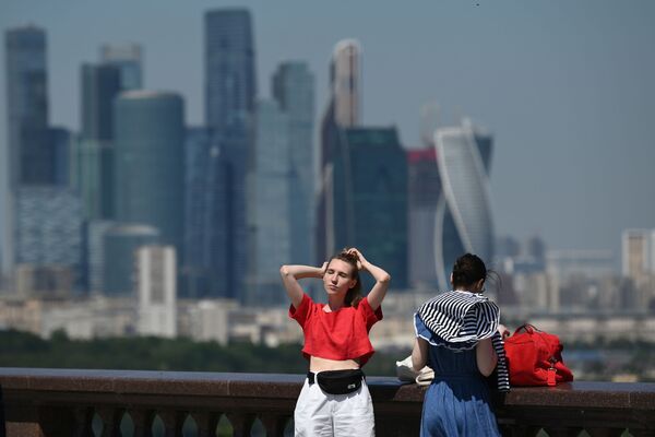 فتيات خلال نزهة على ضفة فوروبيوفيه المطلة على نهر موسكو، هلى خلفية موسكو سيتي، في موسكو، روسيا 20 يونيو 2021 - سبوتنيك عربي