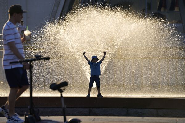صبي يقف بالقرب من نافورة مياه في حديقة في دي إن خا في موسكو، روسيا 20 يونيو 2021 - سبوتنيك عربي