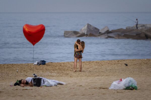 زوجان على الشاطئ في الصباح الباكر في برشلونة، إسبانيا 20 يونيو 2021 - سبوتنيك عربي