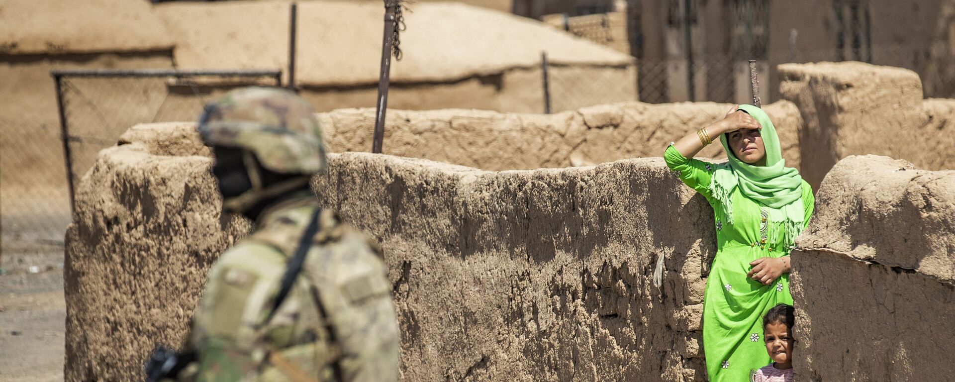   امرأة وطفل ينظران إلى جندي أمريكي يقف خلال دورية عسكرية أمريكية في الرميلان، في محافظة الحسكة شمال شرق سوريا، 22 يونيو 2021 - سبوتنيك عربي, 1920, 17.11.2021