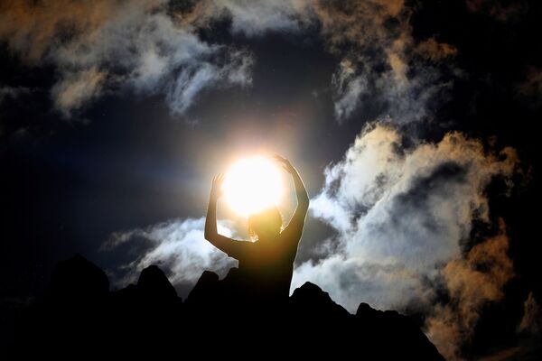 شخص يحتفل بيوم التعامد الشمسي (الانقلاب الشمسي الصيفي) في مرصد كوكينو الصخري، بالقرب من مدينة كومانوفو، مقدونيا في 21 يونيو 2021 - سبوتنيك عربي