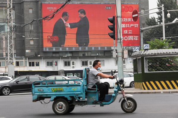 لافتة ضخمة تظهر صورة الرئيس الصيني شي جين بينغ يمنح وساما لعضو الحزب الشيوعي، وانغ شوماو، قبل بدء الاحتفالات بمناسبة الذكرى المئوية لتأسيس الحزب الشيوعي الصيني، الصين، 29 يونيو 2021 - سبوتنيك عربي