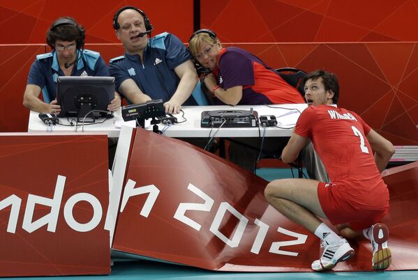 ينظر البولندي ميشال وينارسكي (صاحب رقم 2) إلى الوراء بعد اصطدامه بالجدار الخلفي للجنة التحكيم، ليحتفظ بتسديدة ضد بلغاريا خلال مباراة أولية للكرة الطائرة للرجال، في دورة الألعاب الأولمبية الصيفية 2012، 31 يوليو  2012، في لندن - سبوتنيك عربي