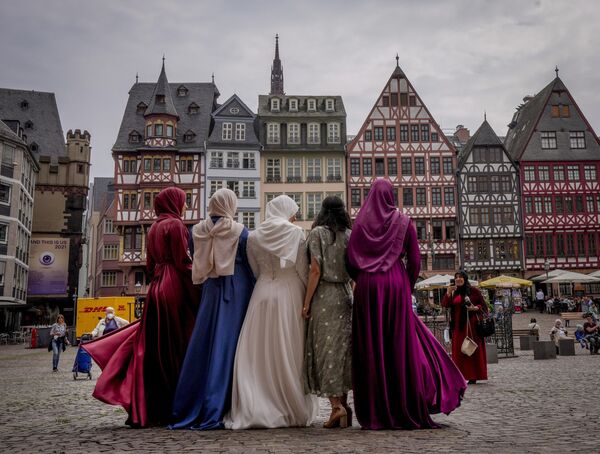 عروس في الوسط وصديقتها يقفن لالتقاط صورة جماعية بعد انتهاء حفل زفاف في قاعة المدينة في ميدان رومربيرغ في فرانكفورت، ألمانيا 25 يونيو 2021 - سبوتنيك عربي