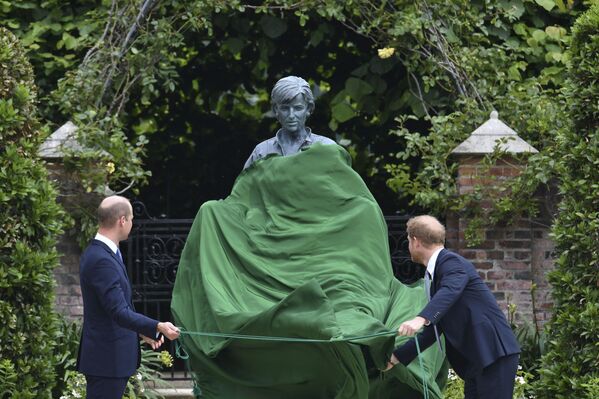 الأميران البريطانيان هاري وويليام يقفان أمام تمثال أمهما الراحلة الأميرة ديانا، بعد إزاحة الستار عنه حديقة سانكن بقصر كنسينغتون في لندن، إنجلترا 1 يوليو 2021 - سبوتنيك عربي
