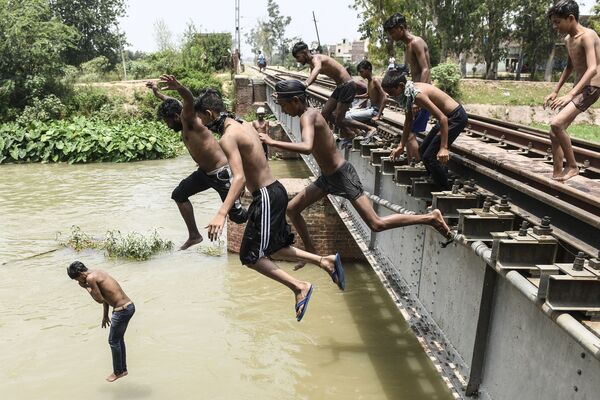 شبان يقفزون في قناة ليبردوا خلال يوم صيفي حار في ضواحي أمريتسار، الهند 27 يونيو 2021 - سبوتنيك عربي