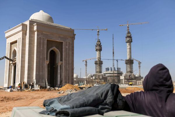 عامل بناء ينظر إلى موقع بناء المسجد المصري الكبير في العاصمة الإدارية الجديدة، مصر 7 مارس 2021 - سبوتنيك عربي