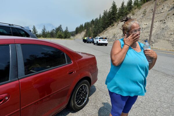 مارثا فان دايك، من أهالي البلدة الصغيرة ليتون، الواقعة في كولومبيا البريطانية، تبكي بعد إجلائهم من منزلها إثر حريق هائل اجتاح المنطقة، كندا، صورة بتاريخ 1 يوليو 2021 - سبوتنيك عربي