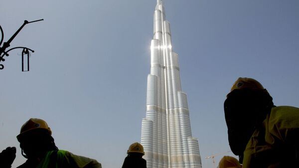 أحد العاملين بجوار برج دبي في الإمارات العربية المتحدة - سبوتنيك عربي