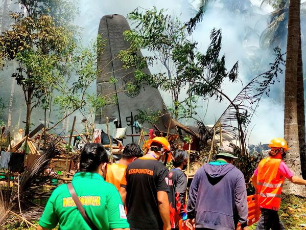 وصول المستجيبون الأوائل موقع تحطم طائرة تابعة للقوات الجوية الفلبينية من طراز لوكهيد سي -130، التي كانت تقل جنودًا عند هبوطها في باتيكول بمقاطعة سولو، الفلبين 4 يوليو 2021 - سبوتنيك عربي