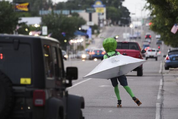 شخص يرتدي زي شخصية رجل فضائي يركب صحناً طائراً يتزلج على طريق شارع الرئيسي خلال مهرجان يو إف أو في روزويل، نيو مكسيكو، 2 يوليو 2021 - سبوتنيك عربي