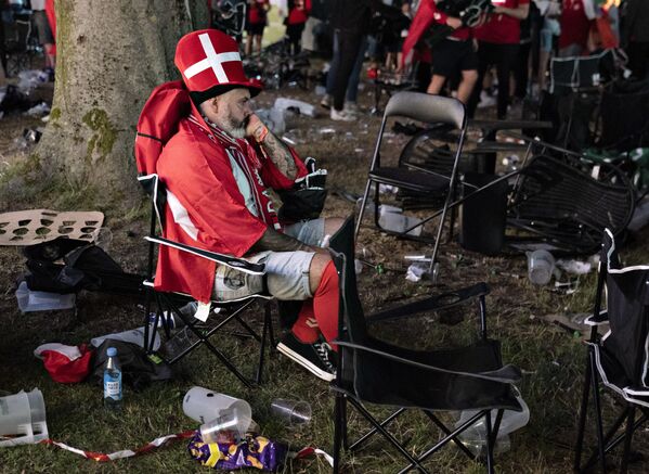 أحد مشجعي المنتخب الدنماركي يجلس في كيلديباركين في آلبورغ بعد هزيمة الدنمارك 2-1 في مباراة كرة القدم نصف النهائي يورو 2020 بين إنجلترا والدنمارك،7 يوليو 2021 - سبوتنيك عربي