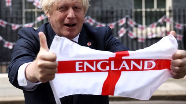 رئيس وزراء بريطانيا، بوريس جونسون، يحمل علم بلاده قبل نهائي بطولة أمم أوروبا يورو 2020 لكرة القدم - سبوتنيك عربي