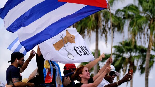 المهاجرون في ليتل هافانا يلوحون بالأعلام الكوبية أثناء ردهم على تقارير الاحتجاجات في كوبا ضد الاقتصاد المتدهور - سبوتنيك عربي