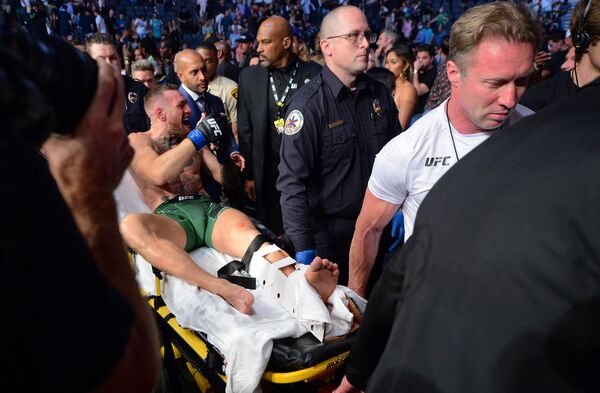 تم نقل المصارع الإيرلندي كونور ماكريغور على نقالة، بعد إصابة تعرض لها أثناء مبارته ضد داستن بويرير في بطولة UFC 264 في ملعب تي-موبايل أرينا، لاس فيغاس، نيفادا، الولايات المتحدة الأمريكية 10 يوليو 2021 - سبوتنيك عربي
