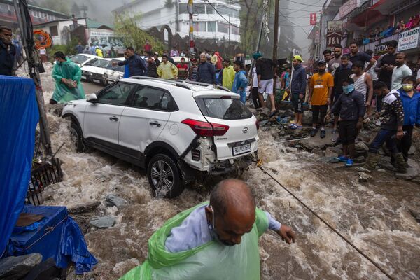 يحاول الناس استعادة سيارة تضررت خلال الفيضانات المفاجئة بعد هطول أمطار موسمية غزيرة في بهاغسوناغ، وهي بلدة سياحية شهيرة في هيماشال براديش، الهند، 12 يوليو 2021 - سبوتنيك عربي