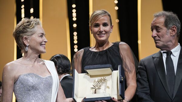 المخرجة جوليا دوكورنو، في الوسط، تحمل السعفة الذهبية لفيلم تيتان - سبوتنيك عربي