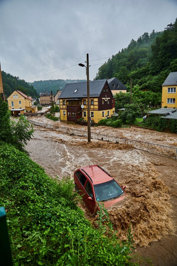 مياه الفيضانات سريعة التدفق في الشوارع وسط هطول أمطار غزيرة في باد شانداو، سكسونية سويسرا، ساكسونيا، ألمانيا 17 يوليو 2021 - سبوتنيك عربي