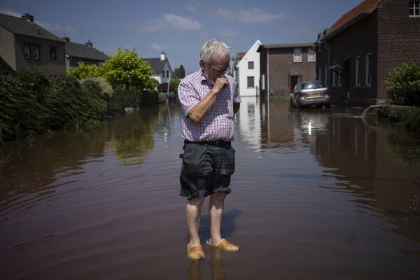 رجل يقف وسط مياه الفيضانات في أحد شوارع بلدة بروميلين، هولندا 17 يوليو 2021 - سبوتنيك عربي