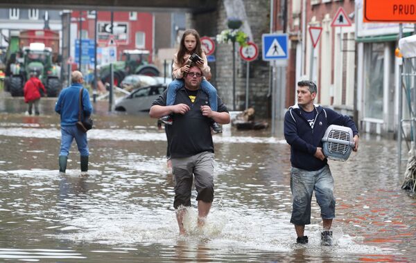المواطنون يسيرون وسط الخراب الذي خلفته مياه الفيضانات في أحد شوارع بيبنستير، بلجيكا 16 يوليو 2021 - سبوتنيك عربي