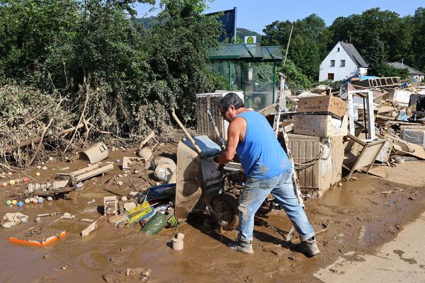 رجل يقوم بإزالة الركام في منطقة سكنية تضررت بمياه الفيضانات في زينتسيغ، ألمانيا 18 يوليو 2021 - سبوتنيك عربي