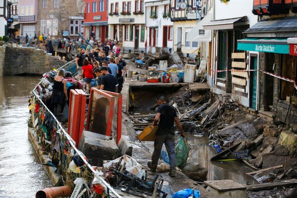 متطوعون وأفراد الشرطة يقومون بتنظيف منطقة تضررت بمياه الفيضانات في مدينة باد مونستر آيفل، ألمانيا 17 يوليو 2021 - سبوتنيك عربي