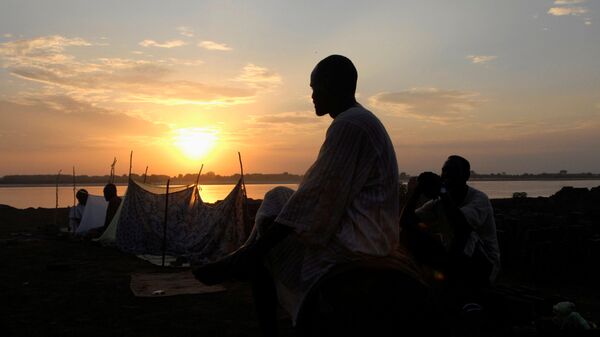 شخص يقف على خلفية غروب الشمس والنيل الأزرق في الخرطوم، السودان 8  يوليو 2007  - سبوتنيك عربي