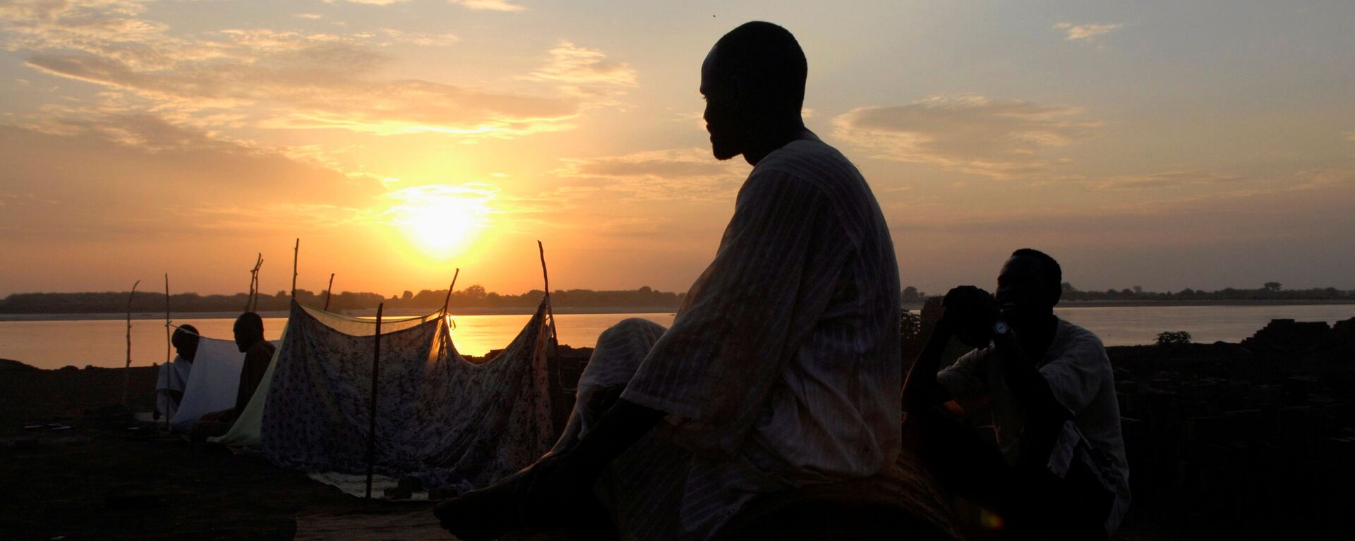 شخص يقف على خلفية غروب الشمس والنيل الأزرق في الخرطوم، السودان 8  يوليو 2007  - سبوتنيك عربي, 1920, 17.10.2021