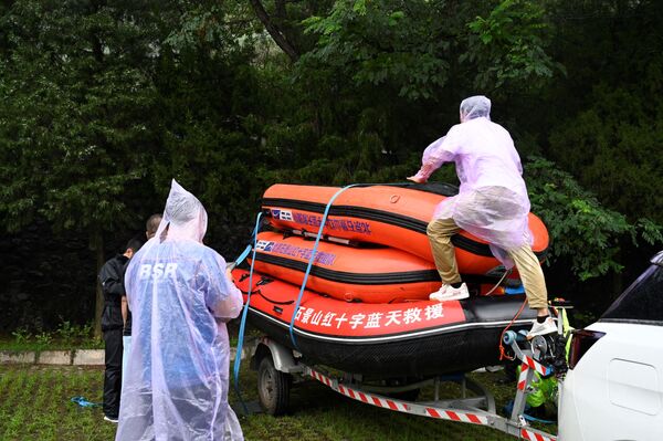 أعضاء فريق الإنقاذ من منظمة بلوسكي يتوجهون إلى مدينة تشنغتشو التي غمرتها مياه الفيضانات، وسط محافظة هينان، الصين 21 يوليو 2021 - سبوتنيك عربي