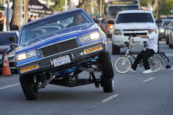 رجل يركب سيارة لورايدر، المركبة على ثلاث عجلات، في بولفار سانسيت، في حي إيكو بارك في لوس أنجلوس الأمريكية 18 يوليو 2021 - سبوتنيك عربي
