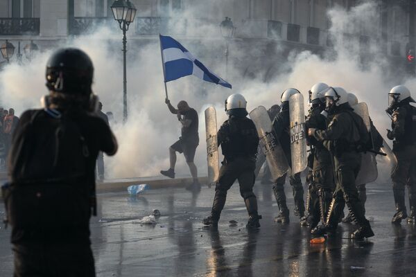 تستخدم الشرطة اليونانية الغاز المسيل للدموع لتفريق المتظاهرين ضد التطعيم خلال تجمع حاشد في ميدان سينتاغما وسط أثينا، 21 يوليو  2021 - سبوتنيك عربي