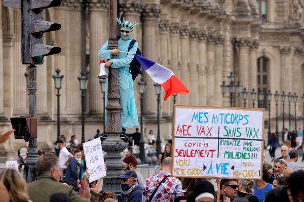 متظاهر يرتدي زي تمثال الحرية يشارك في احتجاجات ضد الإجراءات الجديدة التي أعلنها الرئيس الفرنسي إيمانويل ماكرون لمكافحة تفشي فيروس كورونا (كوفيد -19) في باريس، فرنسا، 17 يوليو 2021 - سبوتنيك عربي