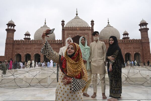 امرأة تلتقط صورة سيلفي مع صديقاتها بعد أداء صلاة عيد الأضحى في مسجد بادشاهي التاريخي في لاهور، باكستان21 يوليو 2021 - سبوتنيك عربي