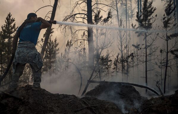 عناصر وزارة حالات الطوارئ الروسية يطفئون حرائق الغابات في ياقوتيا، روسيا  7 يوليو 2021 - سبوتنيك عربي