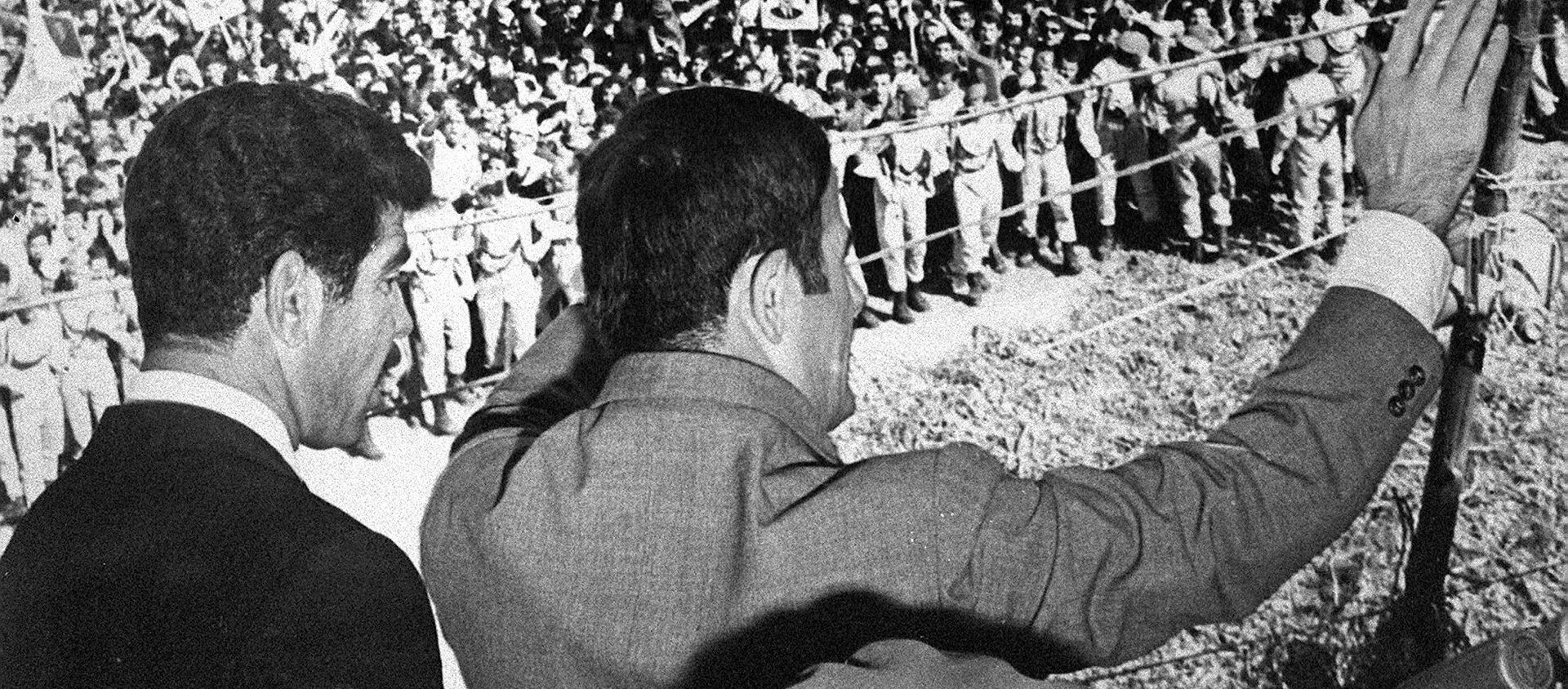 صورة غير مؤرخة تظهر الرئيس السوري حافظ الأسد (إلى اليمين) وهو يحيي الحشود في دمشق. يقف إلى جانبه الرئيس العراقي صدام حسين. - سبوتنيك عربي, 1920, 27.07.2021