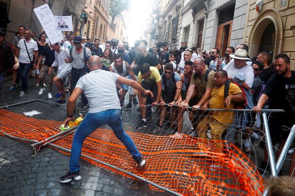 متظاهرون يزيلون حاجزًا للشرطة خلال مظاهرة ضد خطة الممر الأخضر في روما، إيطاليا 27 يوليو 2021 - سبوتنيك عربي