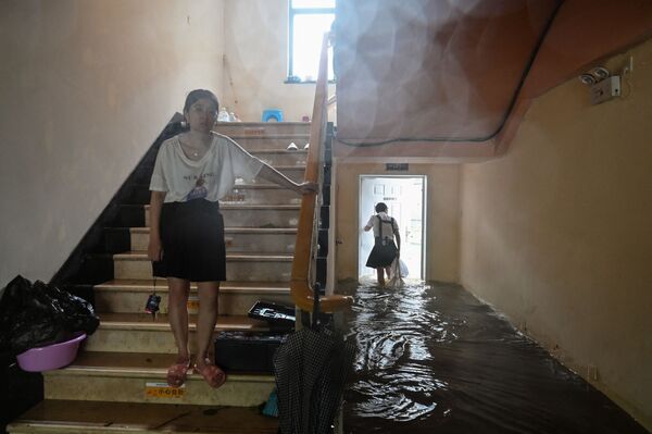 أشخاص في فندق غمرته المياه في مدينة نينغبو بمقاطعة تشجيانغ شرقي الصين، حيث ضرب إعصار إن-فا الساحل الشرقي للصين،  25 يوليو 2021  - سبوتنيك عربي