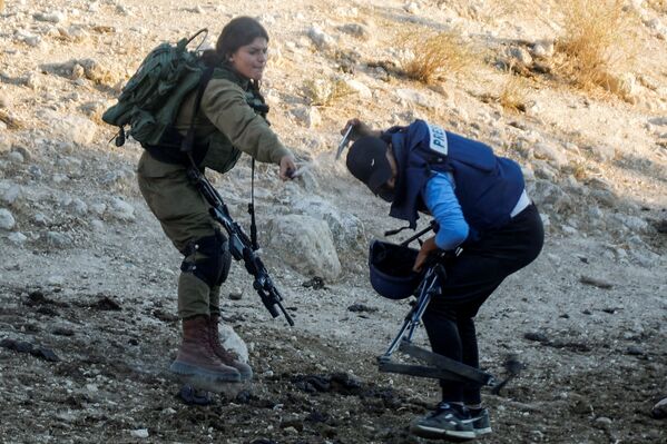 جندية إسرائيلية تقوم برش رذاذ الفلفل باتجاه صحفي خلال تغطيتها لمظاهرة ضد إقامة المستوطنات الإسرائيلية بالقرب من طوباس في الضفة الغربية المحتلة ، 27 يوليو 2021 - سبوتنيك عربي