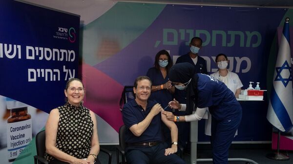 الرئيس الإسرائيلي، إسحاق هرتسوغ، وزوجته، أثناء تلقيهما جرعة ثالثة من لقاح فيروس كورونا المستجد، 30 يوليو/ تموز 2021 - سبوتنيك عربي
