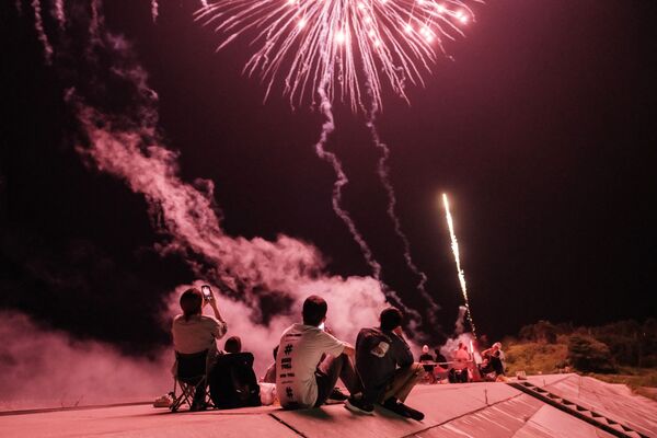 الناس يشاهدون الألعاب النارية على جدار بحري أعيد بناؤه بعد وقوع كارثة تسونامي في عام 2011، في ميناميسوما، محافظة فوكوشيما، اليابان 1 أغسطس 2021 - سبوتنيك عربي