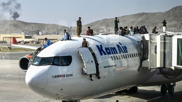 أفغان يتسلقون طائرة في مطار كابول - سبوتنيك عربي