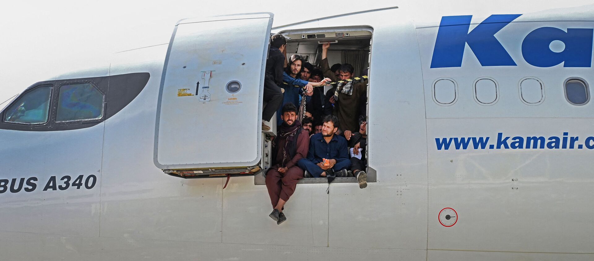 أفغان يجلسون على باب طائرة في مطار كابول - سبوتنيك عربي, 1920, 18.08.2021